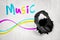 3d rendering of black headphones breaking white wall with colorful `MUSIC` sign