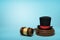 3d rendering of black top hat with red ribbon on sounding block with judge gavel lying beside on light-blue background.