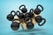 3d rendering of cardboard box in air full of several black kettlebells which are flying out and floating outside on blue