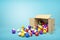 3d rendering of cardboard box lying sidelong with colorful snooker balls inside and in front of it on light-blue