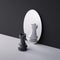 3d rendering, chess game piece, black rook stands in front of the round mirror with different reflection. Duality concept.