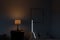 3d rendering of classic bedroom at night with illuminated bedside lamp and light gap from door
