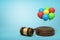 3d rendering of colorful balloons on round wooden block and brown wooden gavel on blue background