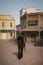 3D rendering of a cowboy or gunman walking towards a saloon with a rifle in his hand in an old wild west town