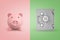 3d rendering of a cute piggy bank on pink background and of a safe on light-green background.