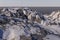 3D rendering of a dog-like robot in a rocky landscape covered with snow near the sea