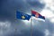 3d rendering of the flags of Kosovo and Serbia waving against a dark cloudy sky