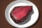 3D rendering of a fresh raw piece of beef on a white plate