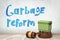 3d rendering of green trash bin on round wooden block with brown wooden gavel and `Garbage reform` sign on white wooden