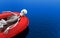 3d rendering. A human skeleton bone lying on red life rescue boat alone on blue water surface background. with clipping path