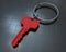 3D rendering - isolated red house key on carbon fiber