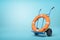 3d rendering of an orange boat lifebuoy on a hand truck on blue background