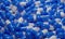 3D rendering of pile of blue and white capsules filling background