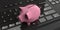 3d rendering pink piggy bank on a keyboard