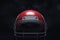 3d rendering of a red American football helmet with its front guard on a dark background.