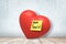 3d rendering of red valentine heart on wooden floor, with yellow post-it note saying `Don`t touch` stuck onto heart.
