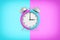 3d rendering of retro alarm clock with bells and a large face hangs on a background in double blue and purple colors.