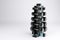 3D rendering. Set of isolated dumbbells for sport on a white background folded on a special black metal stand.