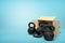 3d rendering of several black kettlebells near open cardboard box that is lying sidelong on light-blue background with