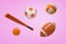 3d rendering of several orange balls for soccer, American football and tennis, with a baseball bat on a pink background.