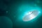 3d rendering of shiny silvery UFO on turquoise gradient bokeh background with copy space.