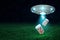 3d rendering of silver metal UFO with medical pills jars on dark night sky and green grass background