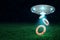 3d rendering of silver metal UFO with two orange lifebuoy rings on dark night sky and green grass background