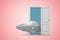 3d rendering of small grey shiny UFO standing in open door on pink background.