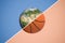 3d rendering of a sphere divided in two with a diagonal line into planet Earth and a basketball.