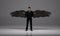 3D rendering : a standing man with a pair of wings at his back pose in black business suit