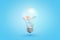 3d rendering of transparent light bulb with liquid and orange lifesaver inside on blue background