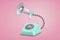 3d rendering of turquoise retro phone with a dial stands on a pink background connected to a megaphone by a black cord.