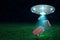 3d rendering of UFO above green field under night sky with three brown travel cases falling down from its open hatch.