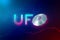 3d rendering of UFO neon sign with silver metal flying saucer instead of letter O on dark blue background