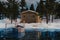 3d rendering of wooden log cabin behind frozen lake in the winter season