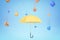 3d rendering of yellow umbrella under the rain of different geometric objects on light blue background.