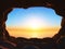 3D view from a cave to a sunset ocean landscape