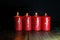 4.Advent. Red Advent candles stand on a wooden floor