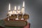 4 burning candles with dripping wax on vintage hard cover books