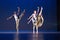 4 four dancers pose against dark background on stage