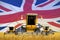 4 orange combine harvesters on wheat field with flag background, United Kingdom UK agriculture concept - industrial 3D