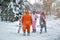 4 people, 2 girls and 2 mens with beard in kigurumi in snow winter forest. Pajama costume pig cow kangaroo and cat. Fun with