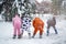 4 people, 2 girls and 2 mens in kigurumi in snow winter forest. Pajama costume pig cow kangaroo and cat. Fun with friends, walking