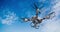 4 propeller drone equipped with camera stabilizer flying under a blue sky with its camera rotating while taking photos. 3D Animati