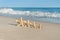 4 sea stars standing on golden sand near sea. Family summer vacation concept
