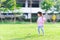 A 4 year old Asian girl enjoys exercising. Bright green lawn. Public areas for sporting activities.