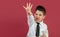 4-year-old boy portrayed with gestures in studio with color background.