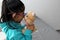 4-year-old brunette Latina girl with glasses represents mistreatment and physical abuse in her teddy bear with bandages on her hea