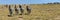 4 zebras lined-up in wide open landscape with zebra herd on the horizon