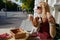 A 40-year-old blonde woman on the street at a table drinks coffee, next to her is a Cavalier King Charles Spaniel dog in a comic